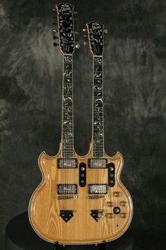 two guitars are sitting on top of a stand