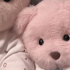 two teddy bears are laying next to each other