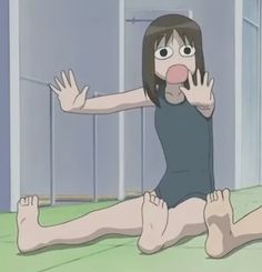 a woman sitting on the floor with her hands up in front of her face and mouth