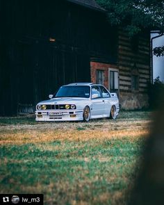 a white car parked in front of a barn