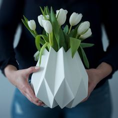 a person holding a vase with flowers in it