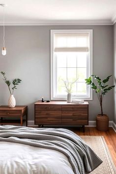 a bedroom with gray walls and white bedding, two planters on either side of the bed