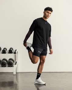 a man in black shirt and shorts holding a tennis racquet