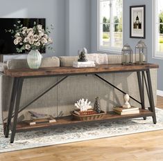 a living room with a couch, coffee table and vase on the end shelf in front of it