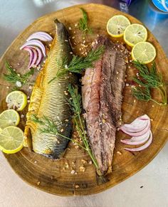 some fish on a wooden plate with lemons and onions