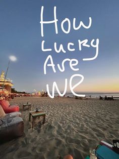 there is a sign that says how lucky are we on the sand at the beach