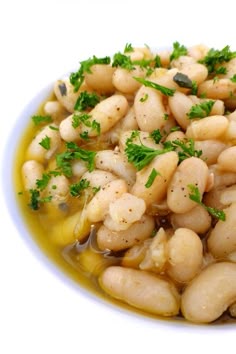a white bowl filled with beans and parsley