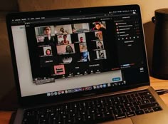 an open laptop computer sitting on top of a wooden desk next to a coffee mug