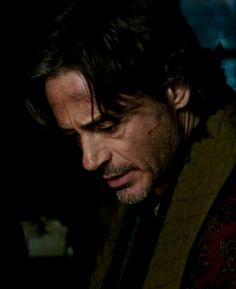 the man is looking down at his cell phone