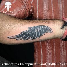 a man's arm with an angel wing tattoo on it