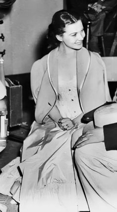 a woman sitting on top of a bed in a room