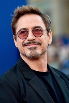 the man with glasses is smiling for the camera