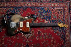 an old guitar sitting on top of a rug