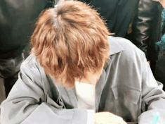 a person sitting at a table writing on a piece of paper