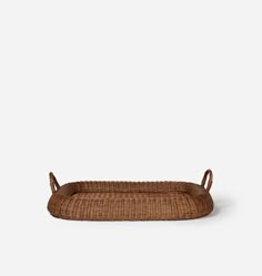 a brown wicker tray with handles on the bottom, and an oval shaped handle