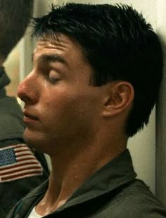 a man in uniform looking at his cell phone with an american flag on the back