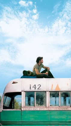a man sitting on top of an old bus