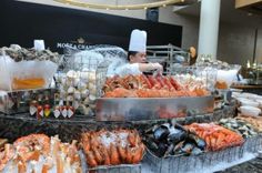 a chef preparing food in a kitchen with lots of clams and lobsters on the counter