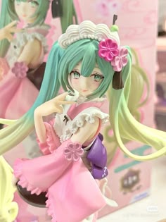 an anime figurine sitting on top of a table next to a pink box