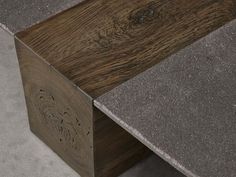 a close up view of the top of a wooden bench with grey concrete and wood