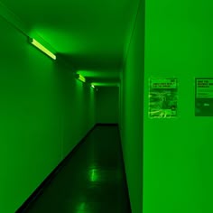 a long hallway with green walls and signs on the wall