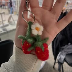 someone is holding their hand up to show the tiny flower on top of the fruit