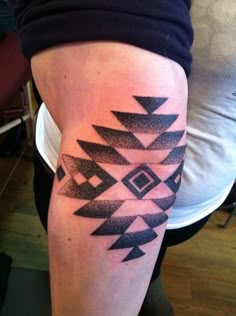 a woman's arm with black and white tattoos on the side of her leg