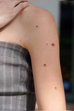 a woman's arm with small stars on the left side of her arm and chest