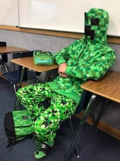 a person in a green costume sitting at a desk