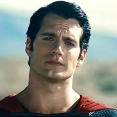 a close up of a person wearing a superman costume and looking at the camera with a serious look on his face
