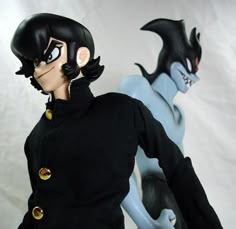 two action figures are posed in front of a white background, one is wearing a black coat and the other has a blue body