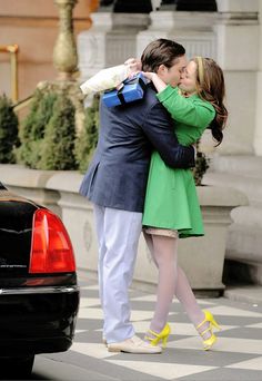a man and woman kissing on the street
