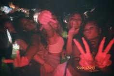 a group of young women standing next to each other holding up their hands in the air