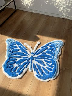 a blue and white butterfly rug sitting on top of a wooden floor