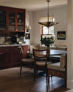 a dinning room table and chairs in front of a window