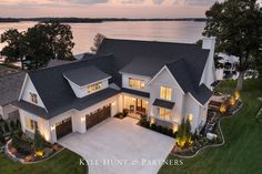 an aerial view of a house with lights on the front and side windows at dusk