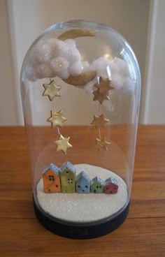 there is a glass dome with stars and houses in it on the table next to a clock