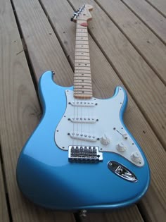 a blue guitar sitting on top of a wooden floor