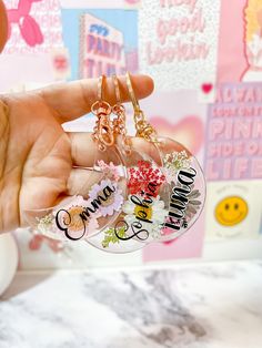 someone is holding up their personalized keychain to show off the charms
