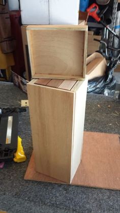 a wooden box sitting on top of a piece of plywood