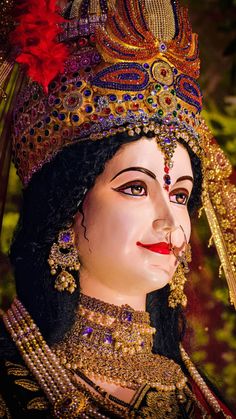 a close up of a statue of a woman wearing a headdress and jewelry