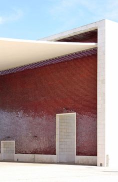 a red and white building with a clock on the wall next to it's entrance