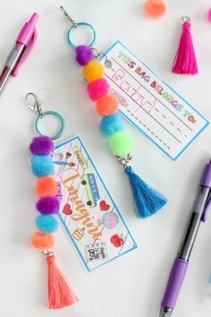 some tassels and pens are laying on a table with a birthday wish card