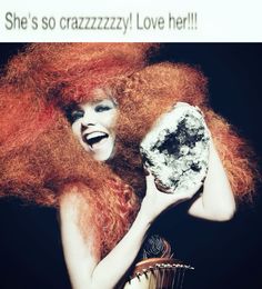 a woman with red hair holding a rock