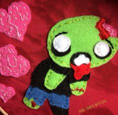 a close up of a small stuffed animal on a red surface with hearts in the background