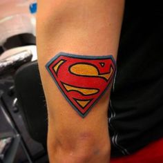 a person with a superman symbol tattoo on their arm