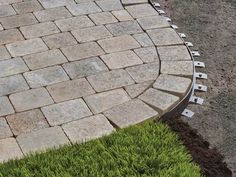 a brick walkway in the middle of some grass
