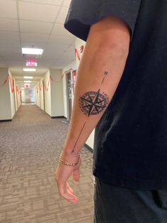 a man with a compass tattoo on his arm