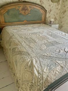 an old fashioned bed in a bedroom with floral wallpaper