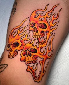 a man's arm with flames and skulls on it